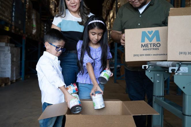 Volunteer as a family at the Metropolitan Ministries Holiday Tent.