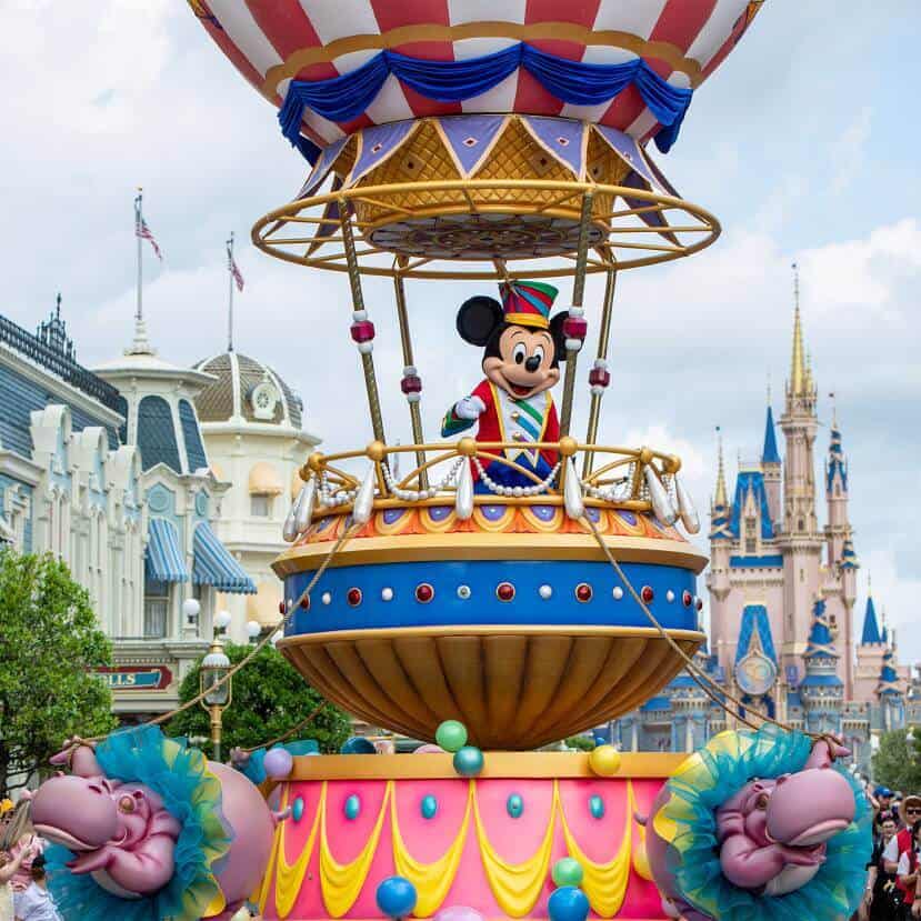 Festival of Fantasy Parade Mickey Mouse character rides a hot air balloon themed float with Cinderella Castle in the background