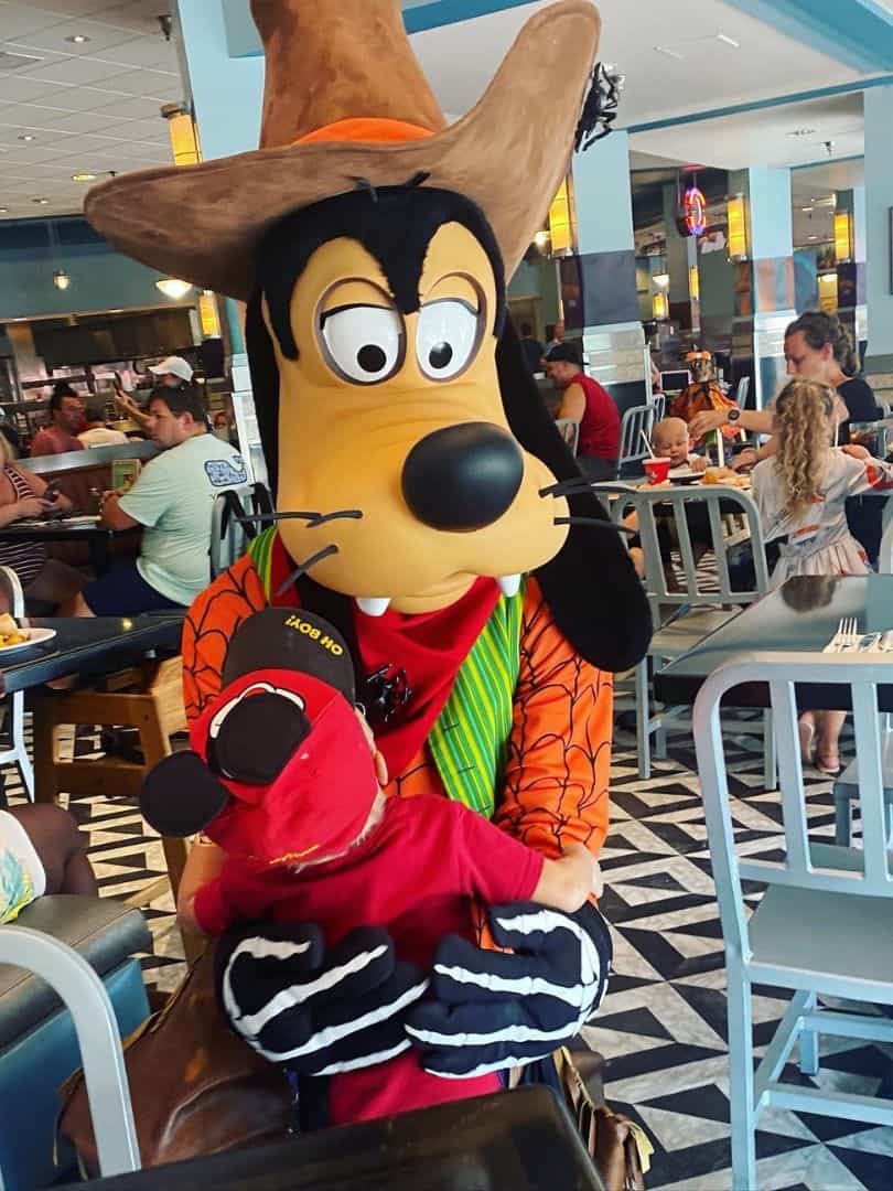 Goofy at Minnie's Halloween Dine Disney's Hollywood Studios hugs a four year old boy