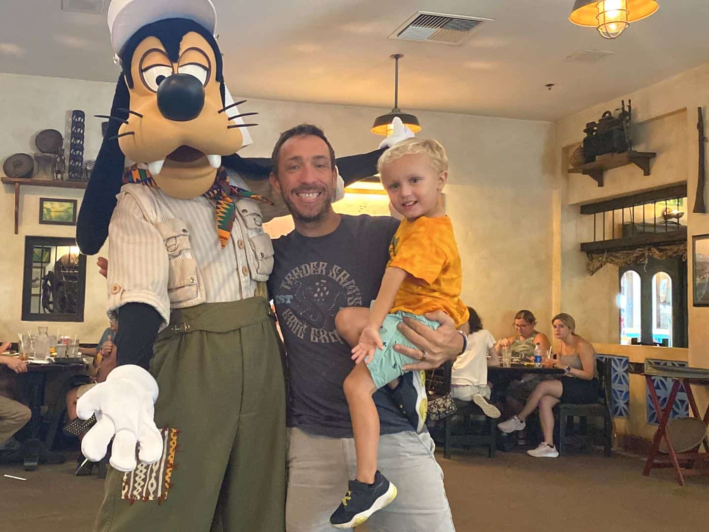 Goofy at Tusker House Character Dining Animal Kingdom poses with a dad and his son