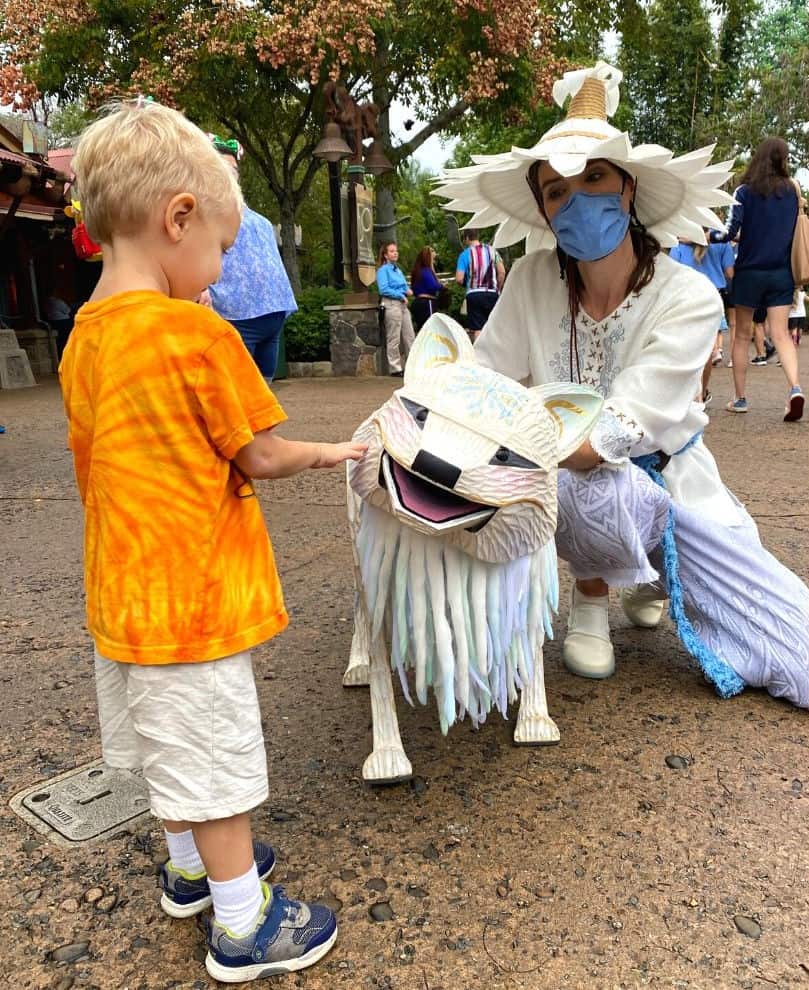 a young boy interacts with a puppet at Merry Menagerie part of the holidays at Disney's Animal Kingdom - Dani Meyering