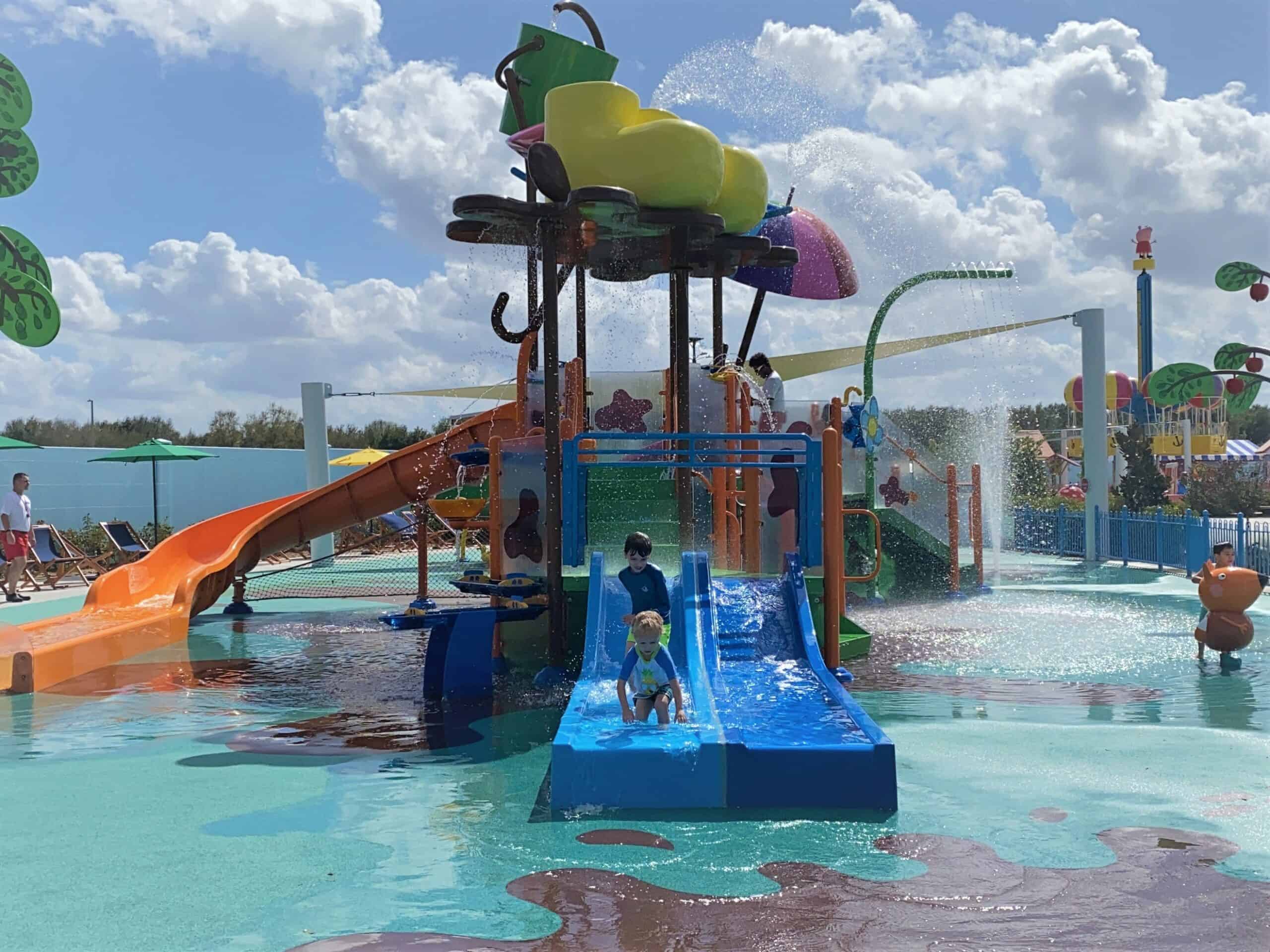 This photo shows the multiple waterslides and fountains at Muddy Puddles Splash Pad at Peppa Pig Theme Park