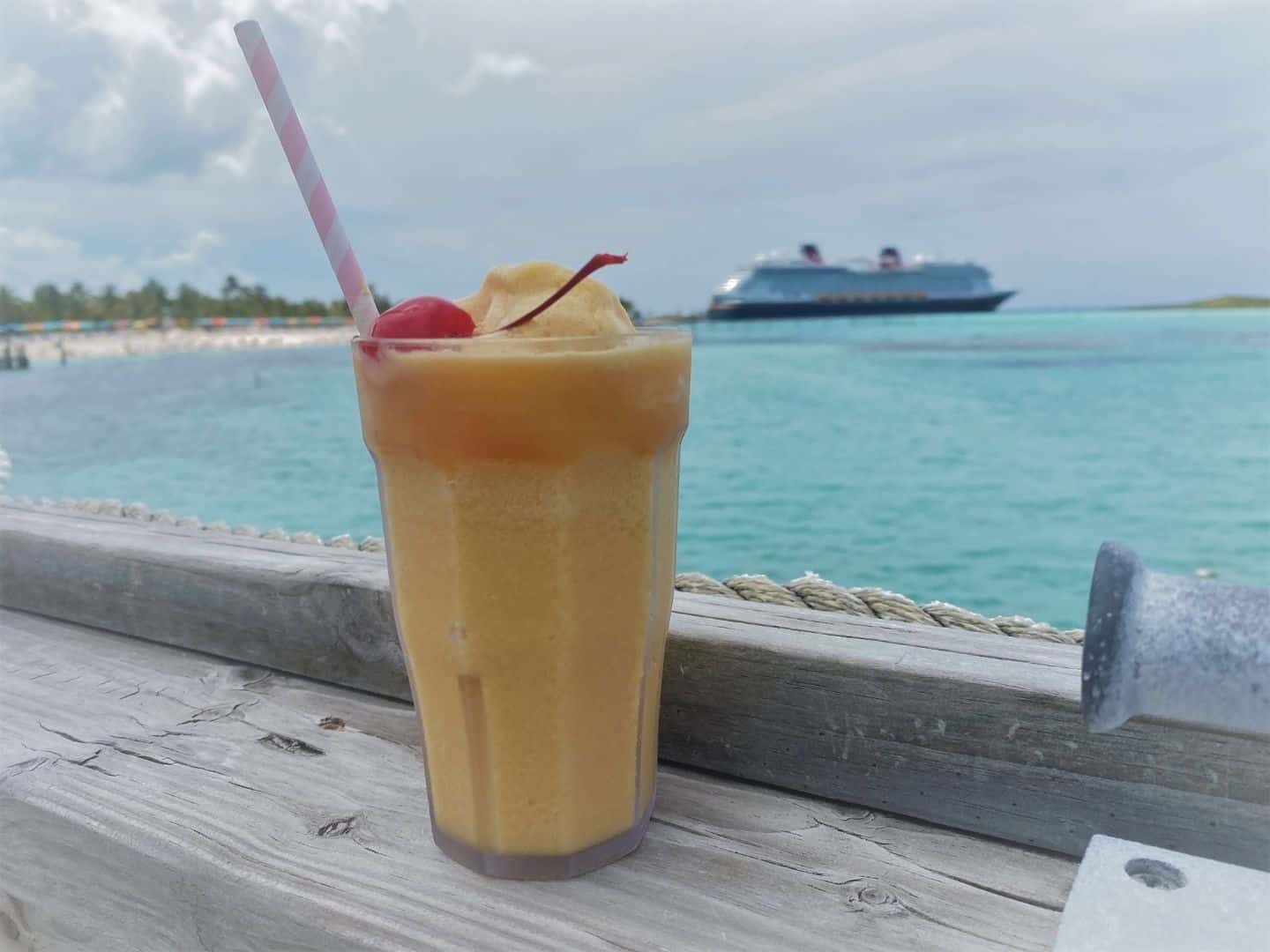 Tropical Drink on Castaway Cay with Disney Wish in background