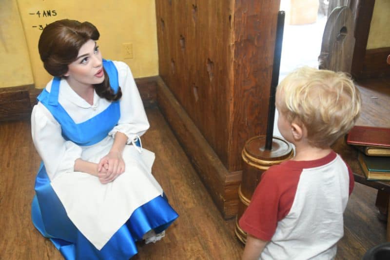 Disney character Belle meets a four year old boy at Magic Kingdom by bending down to his level