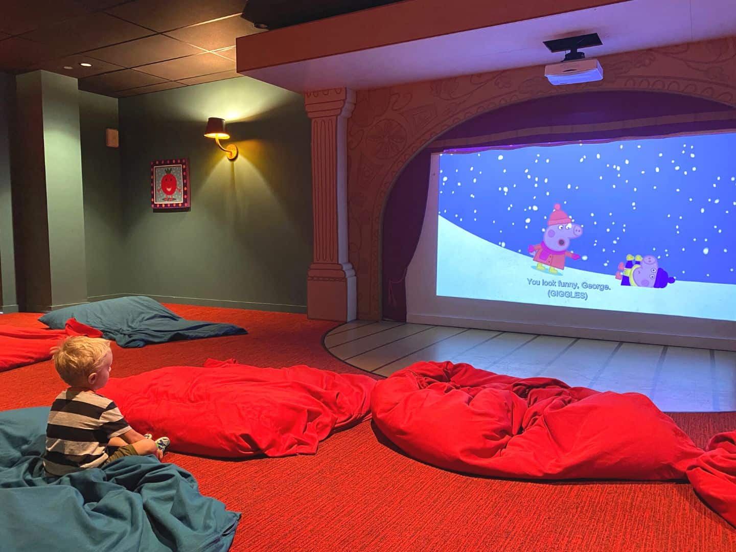 a five year old boy sits inside the The Cinema at Peppa Pig Theme Park 
