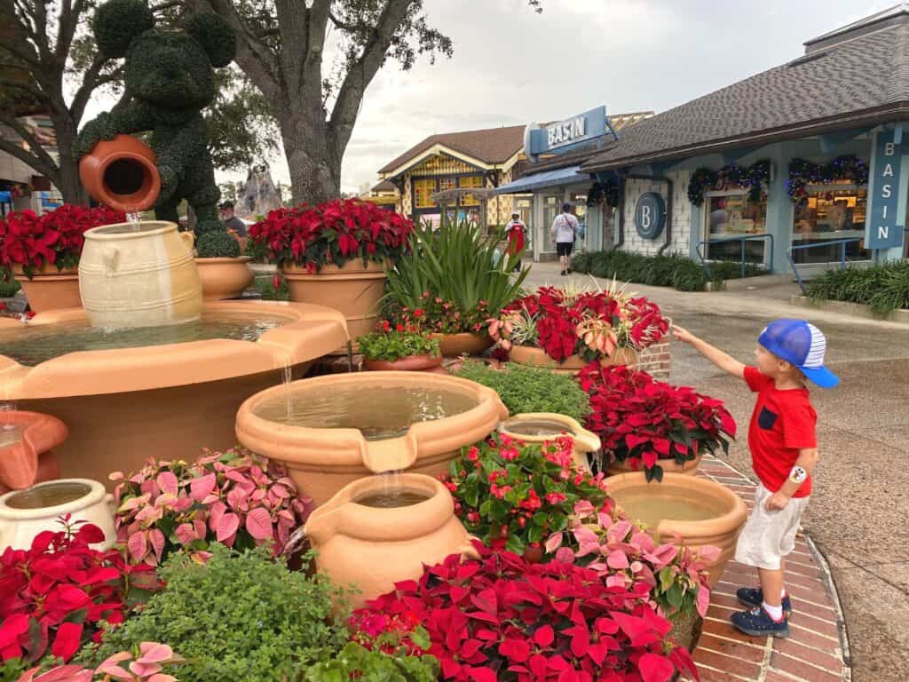 a young boy points at Mickey Fountain at Disney Springs