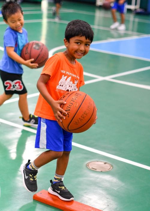 half-day camps CAMP IDS camper playing basketball