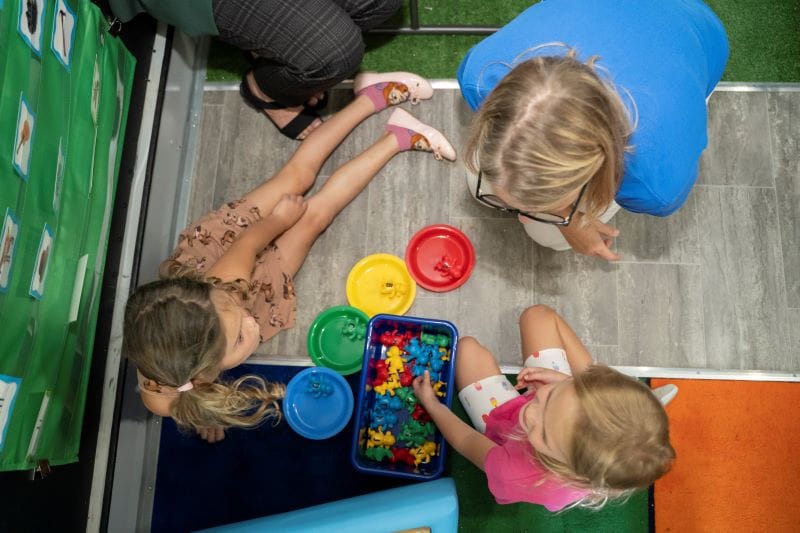 aerial view of a teacher playing with a color sorting game on Paige the LIteracy Bus