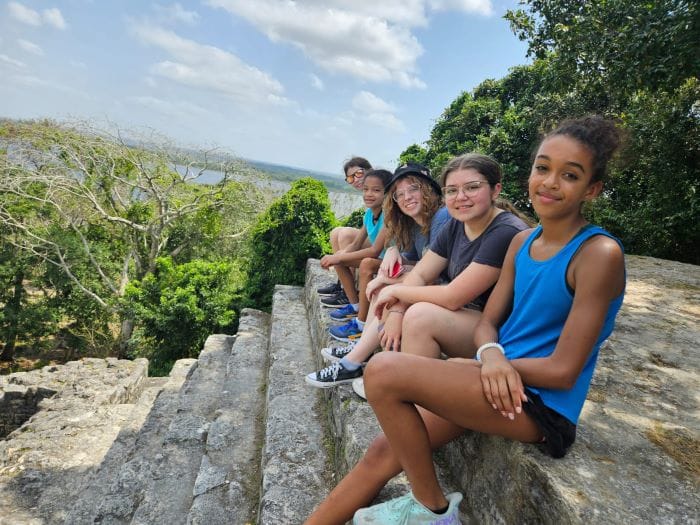 Corbett Prep students on a study abroad trip sitting on a hilltop show the benefits of global learning