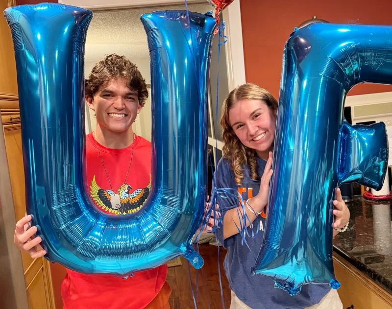 the authors kids hold "UF" balloons in reference to the college application process