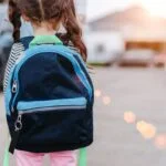 girl wearing backpack shows the importance of Backpack Safety Tips