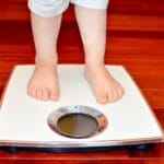 child standing on a stool represents children with obesity