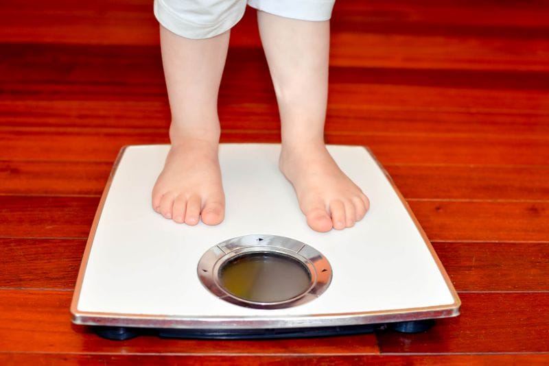 child standing on a stool represents children with obesity