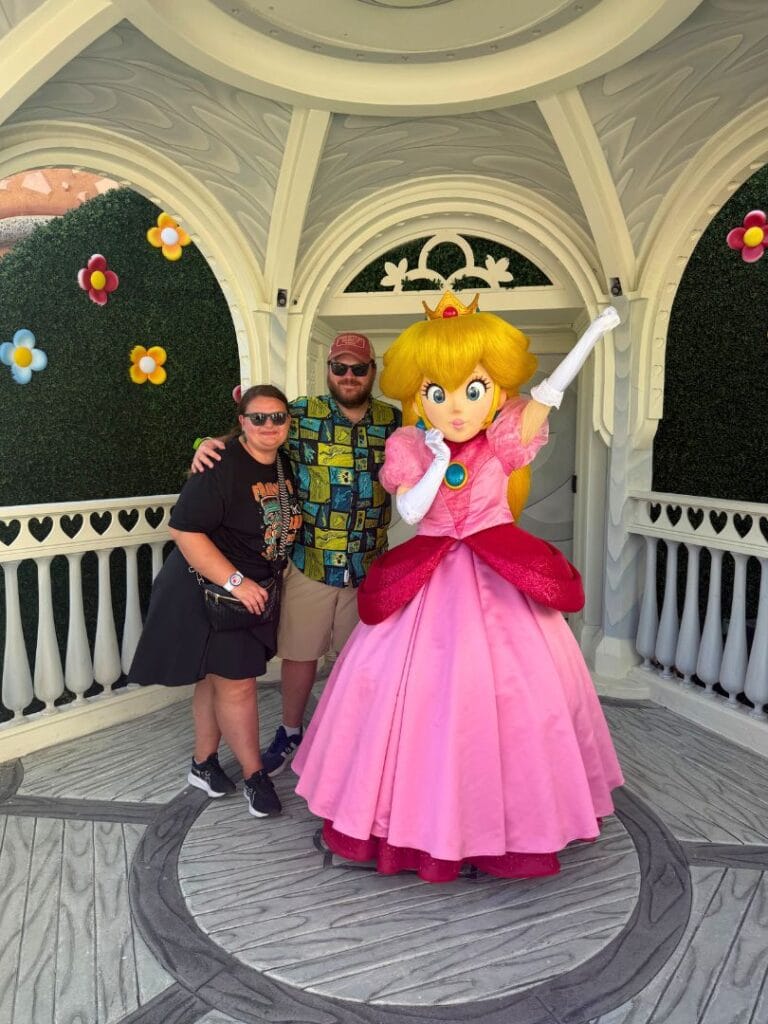Two adults meeting Princess Peach Character at Super Nintendo World in Epic Universe - image from Jodi Caballero