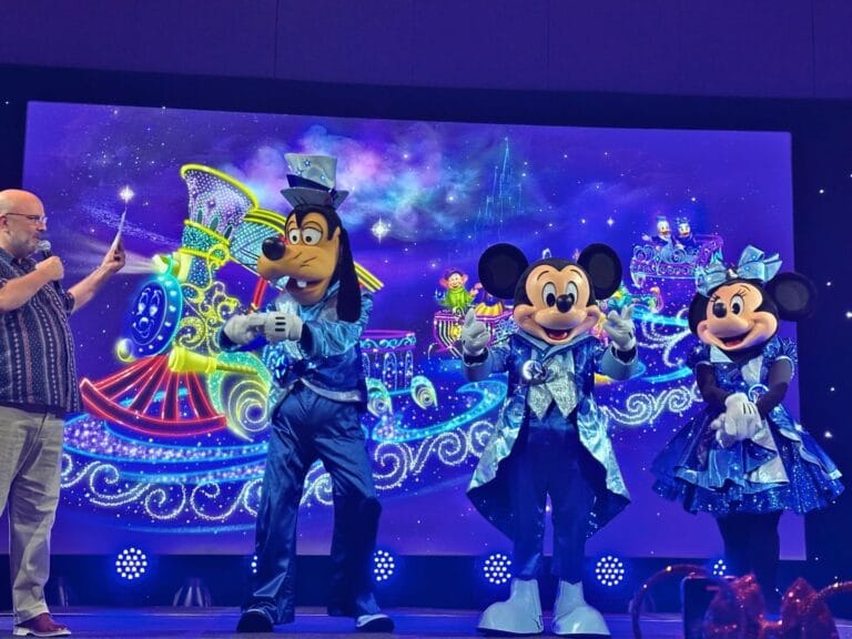 David Duffy with Goofy, Mickey, and Minnie in their parade costumes in front of Finale Float for Disney Starlight nighttime parade concept art - image by Dani Meyering
