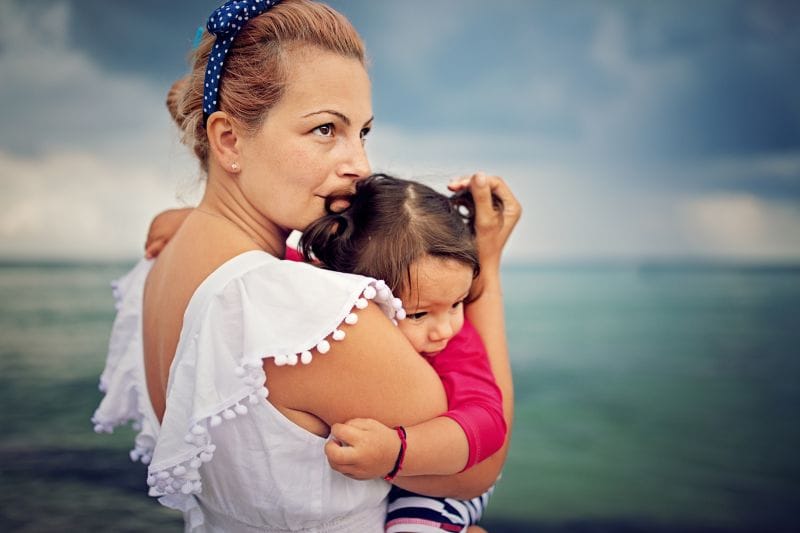 kids and hurricane season, mother with daughter at stormy beach