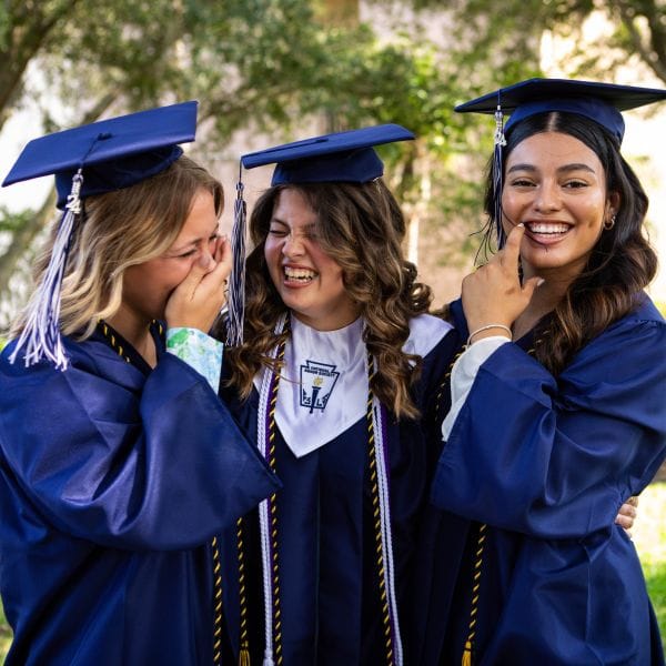 Female graduates laughing together in their cap and gowns