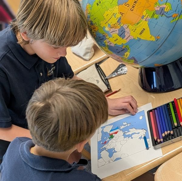 Children looking at a printed map on a desk