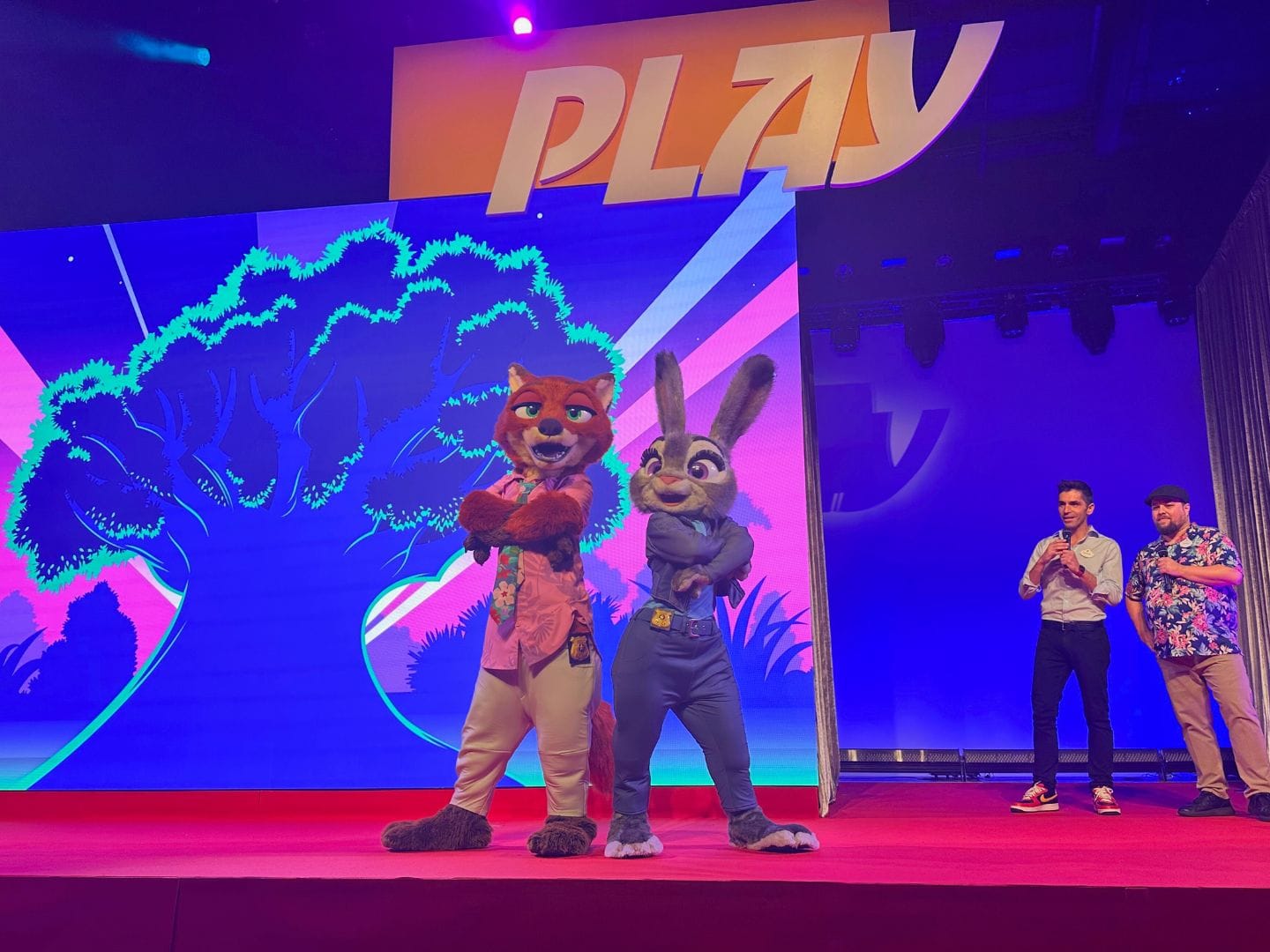Zootopia Characters Nick Wilde and Judy Hopps pose on stage for media event announcing Better Zoogether opening date - image by Dani Meyering
