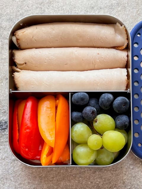Bento box with lunch meat bell peppers and grapes