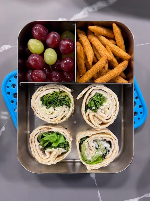 Lunchboxmafia example lunch with chicken wrap, snap pea crisps and grapes.