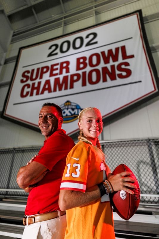 Martin and Emme Gramatica standing underneath a 2002 Super Bowl Champions banner