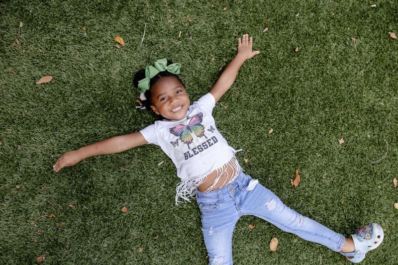 Student laying on park green