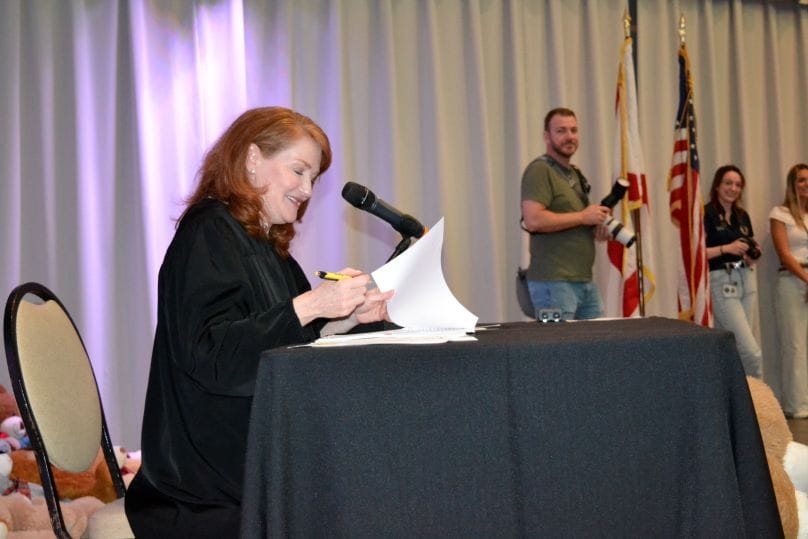 Honorable Judge Leslie Shultz-Kin signing Adoption papers at The Children's Network Adoption Day event at Busch Gardens