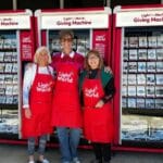Light The World's Giving Machines and a group of volunteers pose for a picture