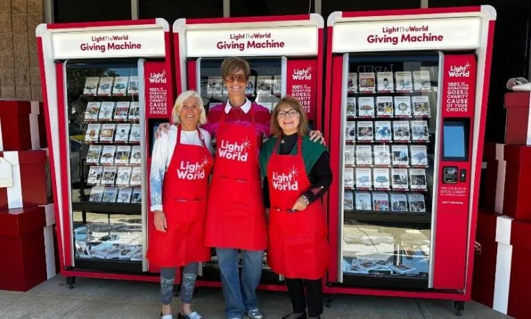 Light The World's Giving Machines and a group of volunteers pose for a picture