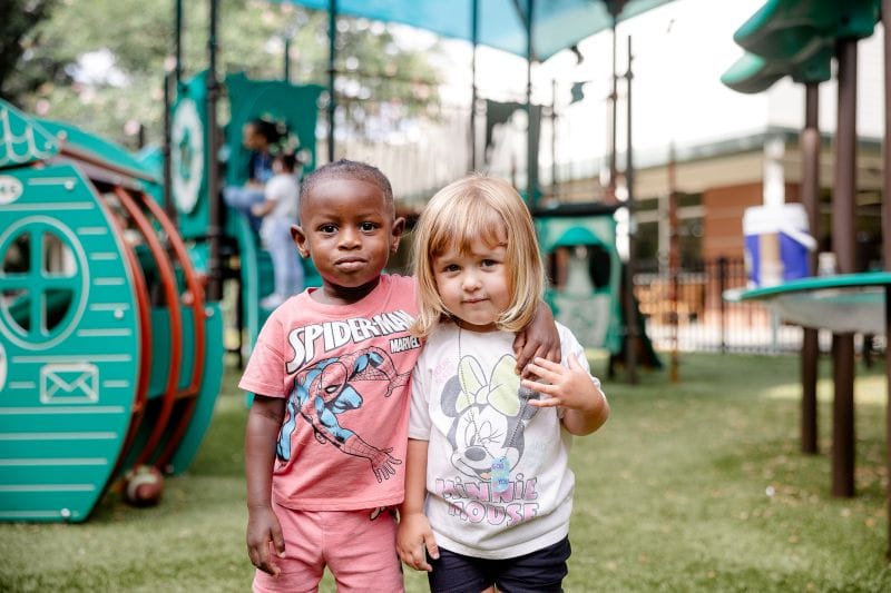 CREATE Friends smiling for photo on playground