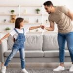 Dad and daughter dancing together in a light colored living room