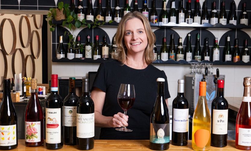 Jennifer Bingham of Cru Hospitality Group poses for a photo featuring some Cru Cellar wines