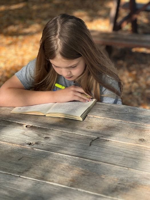 A girl reading outside at dePaul School