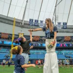 Tampa Bay Rays home games at Tropicana Field. Kids on field with stilt walker during Family Fundays game.