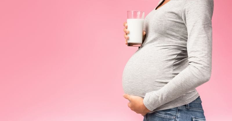 Pregnant woman holding a glass of milk. Presented by Florida Dairy Farmers