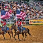 Horse riders carrying flags at the Tampa Bay Rodeo and Family Fest