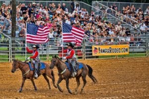 Horse riders carrying flags at the Tampa Bay Rodeo and Family Fest