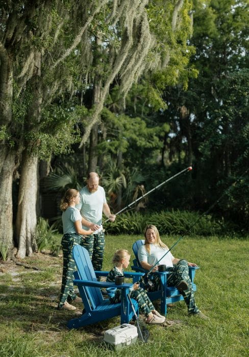Nicole Northway, founder of Emerson and Friends, and her family fishing next to a lake wearing matching clothes