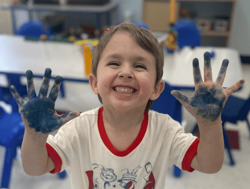 The Goddard School boy with paint on his hands